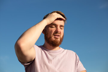 portrait of tired sick exhausted man, handsome guy is suffering from hot Summer heat stroke,...