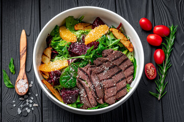 Salad with roast beef and caramelized beets with orange fillet, potatoes, parmesan, salad mix and olive oil