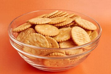 A bowl of round cookies on a yellow background. A tasty and sweet snack.