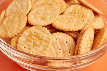 A bowl of round cookies on a yellow background. A tasty and sweet snack.