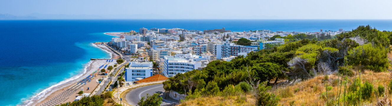 Colorful umbrellas and sunbeds on an empty beach resort - vacation concept on Greece islands in Aegean and Mediterranean seas. Akti Kanari Beach under Monte Smith in Rhodes city.