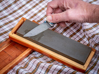 Pocket knife with unique Damascus patter getting a sharpened