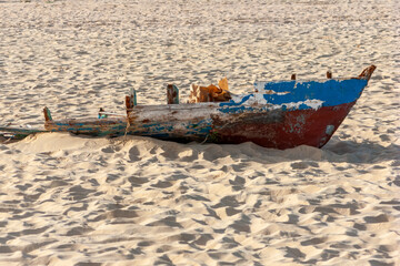 Small fishing boat broken by a storm and abandoned on a beach of Sal Island in Cape Verde, Africa.