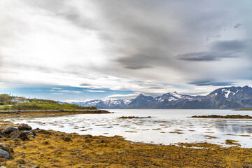 Mountain scenery in Lofoten, Norway, during a sunny day with clouds in spring, overlooking the sea