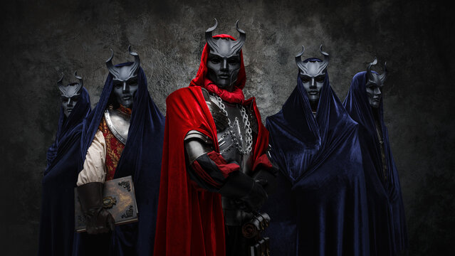 Studio Shot Of Esoteric Brotherhood Of Five People With Robes And Horned Masks.