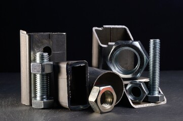 composition of nuts bolts and scraps of metal laid out on a dark background.