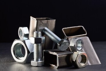 composition of nuts bolts and scraps of metal laid out on a dark background.