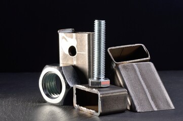 composition of nuts bolts and scraps of metal laid out on a dark background.