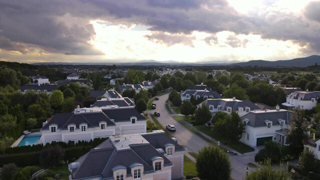 Aerial drone view of American style suburban neighborhood, sunset day , mountains background