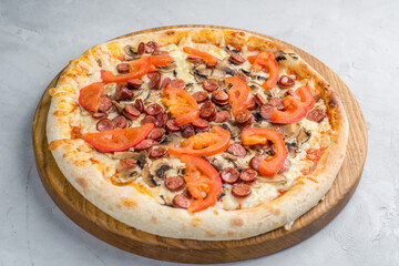 Pizza with vegetables, sausages and ham
