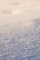 Snow in yellow light at sunset, background