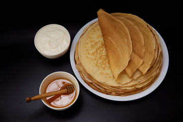 Thin pancakes with sour cream on board