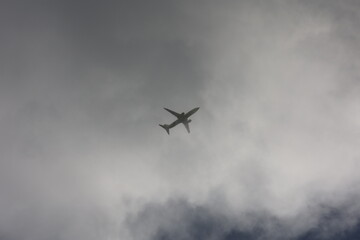 Fototapeta na wymiar an airplane flies high in the sky through the clouds