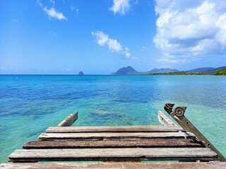 Pier at beach in Landscape of the French West Indies. The wooden bridge stretches into the sea....