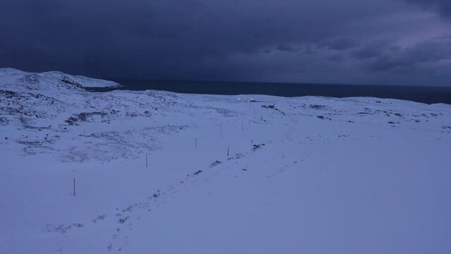 Aerial drone view of severe nature of Barents sea coast in winter covered by snow