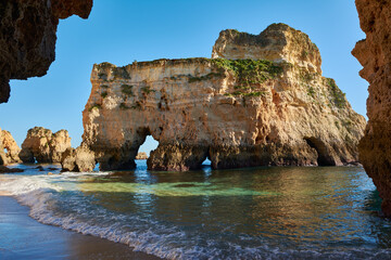 Fototapeta na wymiar Limestone rock with grottoes washed by the ocean