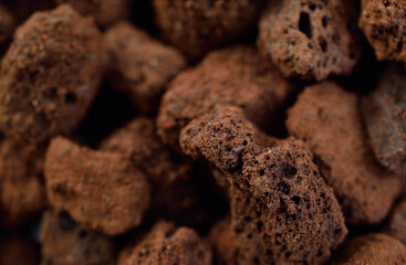 Porous brown volcanic rock. Lava stone, pumice stone, or volcanic pumice with distinctive pores