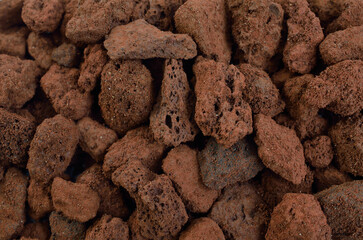 Porous brown volcanic rock. Lava stone, pumice stone, or volcanic pumice with distinctive pores