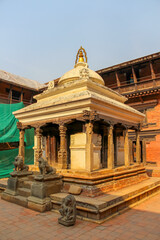 Small white stone hindu Keshav Narayan Temple with guarding lion statues located in chowk of Taleju...