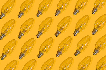 Yellow background. Electric light bulbs pattern. An old glass electric light bulb with a tungsten...