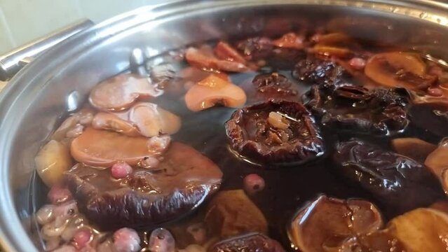 Preparation of compote in a pot from dried pears, apples, red currants. The process of cooking, boiling. Stewed fruit.