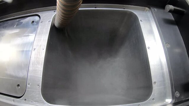 Pouring metal powder into working surface of 3D printer for metal. Selective laser melting technology. SLM. Flowing Metal Powder inside 3d printer for metal. Filling working chamber with powder.