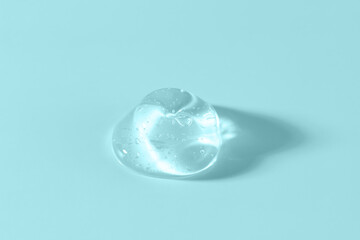 Cosmetic transparent gel serum swatch with bubbles with soft shadow on blue background. Texture...