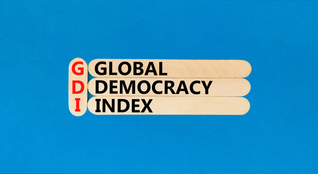 GDI global democracy index symbol. Concept words GDI global democracy index on wooden stick on a beautiful blue table blue background. Business and GDI global democracy index concept. Copy space.