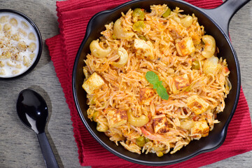 Top view of Veg biryani in plate served with raita