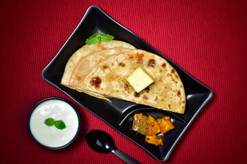 Aloo paratha served with curd and pickle, stuffed butter paratha