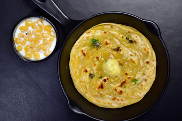 top view of Lachha paratha served with raita