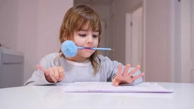 Smart Young Caucasian Girl Preshooler Doing Math Homework Counting Numbers with Her Fingers
