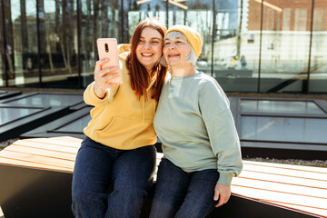 Two women together wear casual clothes doing selfie shot pov on mobile cell phone. Family day concept. Young woman and senior middle aged mom spending time together