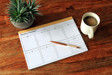 weekly planner resting on a coffee table - obrazy, fototapety, plakaty