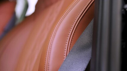 Close view of leather interior of luxury car, beige. Comfortable perforated seats in business sedan for comfortable ride.