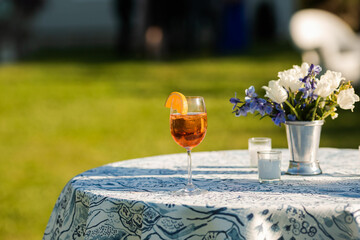 Aperol Spritz in glass on sunny table at outdoor summer wedding