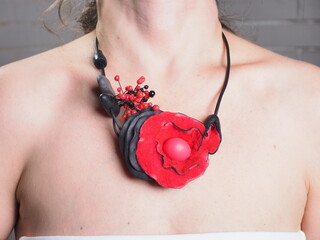 red necklace with a flower around the neck of a young woman