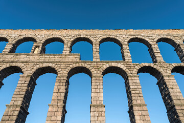 Fototapeta na wymiar Beautiful Roman aqueduct of Segovia Spain against a blue sky