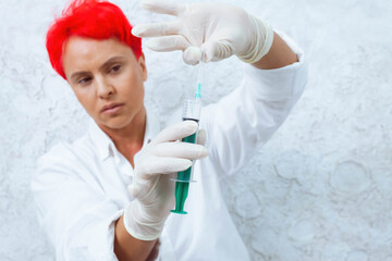 Naklejka premium Woman with a short bright red hair in a white room holding needle. Drug addiction concept.
