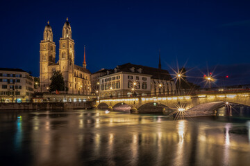 View of the Grossmünster and the Münster bridge in Zurich over the Limmat river in the evening