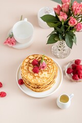 Spring stilllife breakfast top view. Pancakes with tea set with roses flowers.