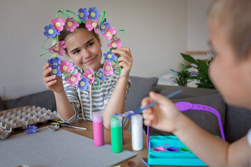 Transformation an ordinary egg carton into a beautiful Easter flower wreath. Kids show the creative...