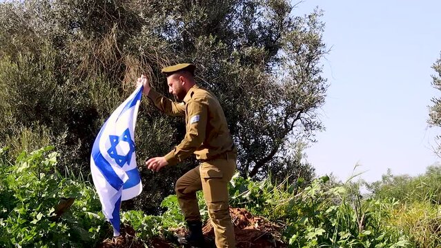 Israeli Soldier, climbing to the top of a mountain, kisses the Flag of Israel and salutes the Flag. Video themes: Patriotism and Army, Tzahal - IDF or Israel Defense Forces, Independence Day Israel