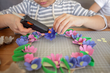 DIY project with kids, an egg carton is transformed into Easter flower wreath. Creativity and...