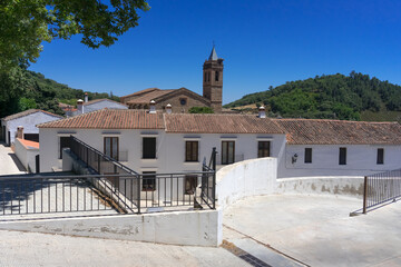 Obraz premium Beautiful street with its typical white facadesand the San MArtin church in the background in Almonaster La Real in Huelva province, Andalucia, Spain.