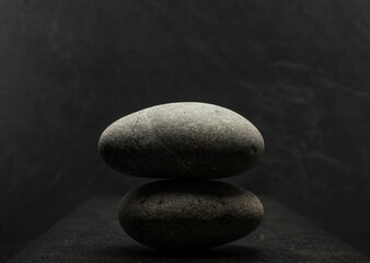 Fototapeta na wymiar gray zen stone with shadow on dark gray background for podium background
