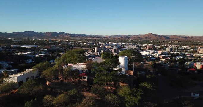 4K high quality aerial video drone footage of green hills and posh residential historical area with houses and old mansions on sunny afternoon in Windhoek, Namibia in southern Africa