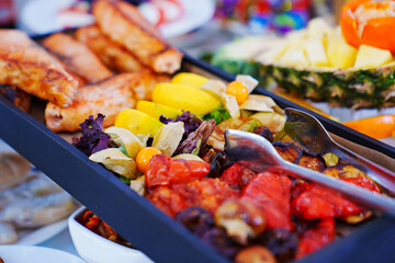 rectangular black dish with grilled fish and vegetables. 