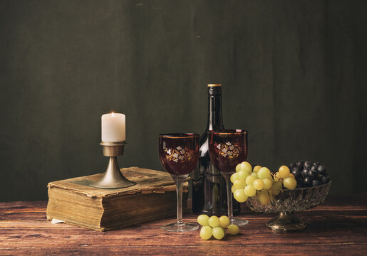 Antique still life with wine, book and grapes.
