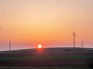 Fototapeta na wymiar Strommasten in der Ferne imi Sonnenuntergang